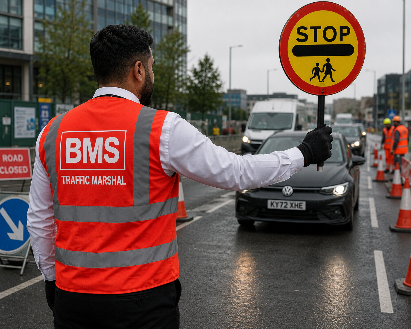BMS traffic marshal in hi-vis holding a stop sign to control vehicles at a UK site entrance